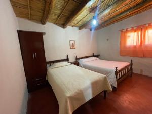 una habitación con dos camas en una habitación en Bello Atardecer, en Tilcara