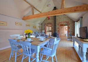 Hawthorne and Rainbow Cottage في Roughton: غرفة طعام مع طاولة وكراسي خشبية