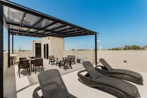 a patio with chairs and a table on a roof at CASA ALDAMA- Style & Convenient Apartments in Cancún