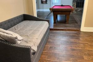 a bed sitting in a living room with a table at Pool/ Outdoor kitchen/Pool table in Houston +23 photos
