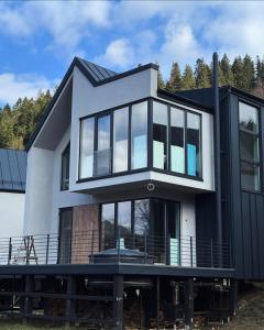 ein Haus mit großen Fenstern auf einem Dock in der Unterkunft Wood-House in Tatariw