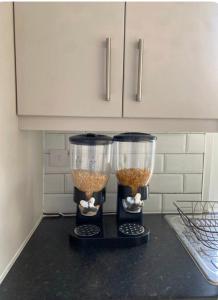 two food processors sitting on top of a kitchen counter at Cosy Citrine Suite - in London