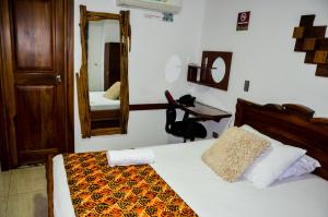 1 dormitorio con cama con espejo y escritorio en Hotel Shaira 2 en Quibdó