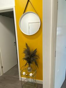 un espejo en una pared amarilla en un pasillo en Cosy Citrine Suite - en Londres