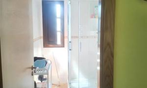 Łazienka z prysznicem i szklanymi drzwiami w obiekcie 2 bedrooms house with furnished garden and wifi at Grandas de Salime w mieście Grandas de Salime