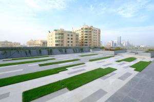 a patio with grass and buildings in the background at Farhan Tower in Juffair