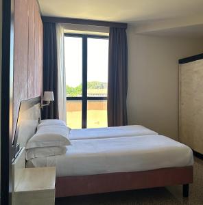 a hotel room with two beds and a window at Hotel Diamante in Corbetta