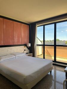 a bedroom with a large bed and a large window at Hotel Diamante in Corbetta
