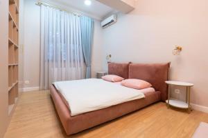 1 dormitorio con 1 cama con 2 almohadas rosas en New apartment in Vake for rent en Tiflis