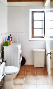 biała łazienka z toaletą i oknem w obiekcie 2 bedrooms house with furnished garden and wifi at Grandas de Salime w mieście Grandas de Salime