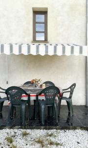 stół z 4 krzesłami siedzący pod oknem w obiekcie 2 bedrooms house with furnished garden and wifi at Grandas de Salime w mieście Grandas de Salime