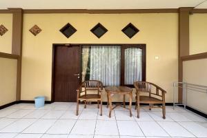 a dining room table and two chairs on a porch at Taxa Raya Guest House in Legian