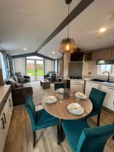 a kitchen and living room with a table and chairs at Lottie's Lodge With Hot Tub in Malton