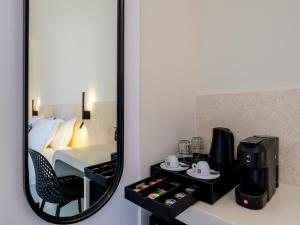 Yalos Hotel Sunset view Mykonos town private rooms في مدينة ميكونوس: مرآة في غرفة مع غرفة في الفندق