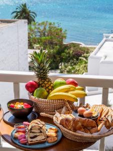 a table topped with baskets of fruit and bread at Yalos Hotel Sunset view Mykonos town private rooms in Mikonos