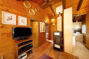 a living room with a television and a kitchen at Orserose Chalet 4 Al Vant in Forno di Zoldo