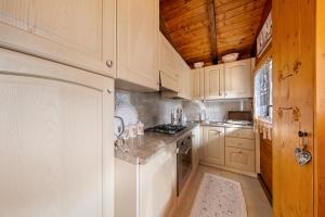 a kitchen with white cabinets and a stove top oven at Orserose Chalet 6 I Scarpet in Forno di Zoldo