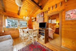 ein Esszimmer mit einem Tisch und einem TV in einer Hütte in der Unterkunft Orserose Chalet 6 I Scarpet in Forno di Zoldo