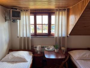 um quarto com duas camas e uma mesa e uma janela em Dom Wypoczynkowy Morski Oddech em Leba