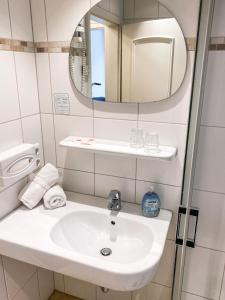 a bathroom with a sink and a mirror at Hotel Garni Silvana in Sankt Peter-Ording