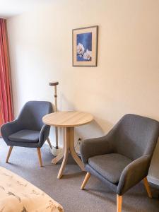 2 sillas y una mesa en una habitación en Hotel Garni Silvana en Sankt Peter-Ording