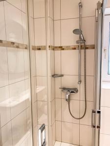y baño con ducha y puerta de cristal. en Hotel Garni Silvana en Sankt Peter-Ording