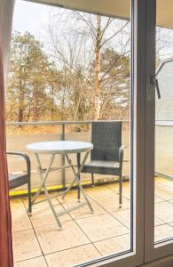uma mesa e cadeiras numa varanda com uma janela em Hotel Garni Silvana em Sankt Peter-Ording
