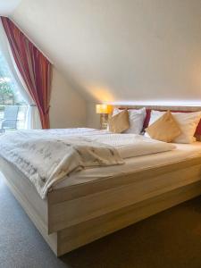 a large bed in a room with a window at Hotel Garni Silvana in Sankt Peter-Ording