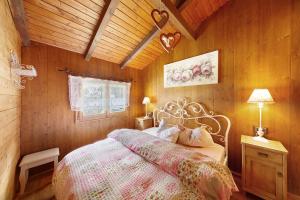 a bedroom with a bed in a wooden room at Orserose Chalet 3 I Ciodi in Forno di Zoldo