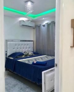 Un dormitorio con una cama con luces verdes. en Aparta air, en Pantoja