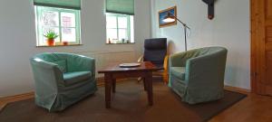 アルンシュタットにあるFerienwohnung Wenzlaffの椅子2脚、テーブル、ランプが備わるお部屋