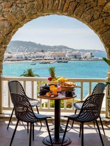 a table with a bowl of fruit on a balcony at Yalos Hotel Sunset view Mykonos town private rooms in Mikonos