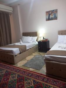um quarto com 2 camas e um tapete em Prumime pyramids inn no Cairo