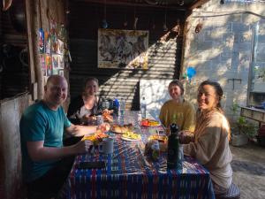 eine Gruppe von Menschen, die um einen Tisch sitzen in der Unterkunft “Posada Vicentas” compartir con una familia Tz’utujil in San Juan La Laguna