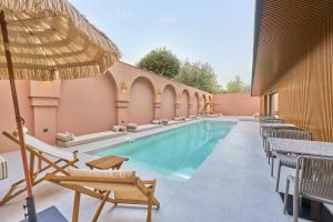 einen Pool mit Stühlen und einem Sonnenschirm in der Unterkunft La Maja Hotel in Antalya
