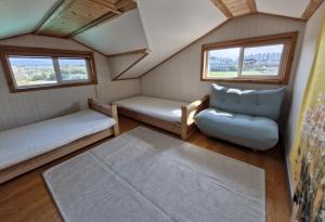 Habitación pequeña con 2 camas y sofá en 나무집 게스트하우스, en Jeju