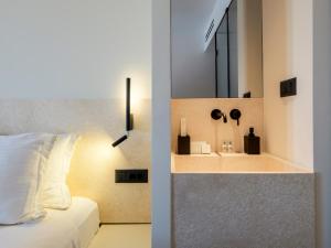 a bedroom with a bed and a sink with a mirror at Yalos Hotel Sunset view Mykonos town private rooms in Mýkonos City