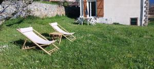 two chairs sitting in the grass next to a house at Le Serre in Belvédère