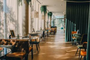 a restaurant with couches and tables and chairs at RVHotels Palau Lo Mirador in Torroella de Montgrí