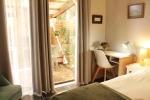 een slaapkamer met een bed, een bureau en een raam bij Woodlea self-catering flatlet in Pringle Bay