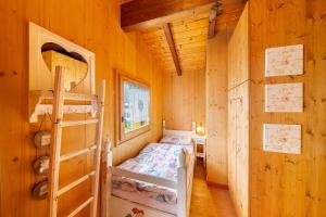 a bedroom with a bed in a wooden cabin at Orserose Chalet 8 I Fer Da Stir in Forno di Zoldo