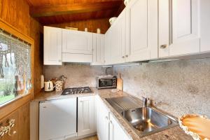 a kitchen with white cabinets and a sink at Orserose Chalet 8 I Fer Da Stir in Forno di Zoldo