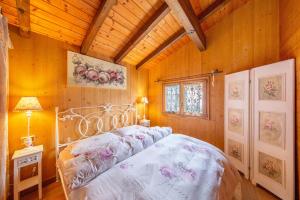 1 dormitorio con cama y techo de madera en Orserose Chalet 8 I Fer Da Stir, en Forno di Zoldo