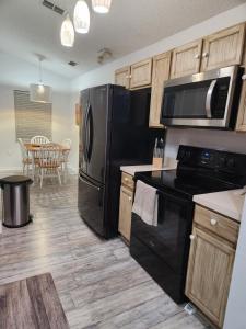a kitchen with black appliances and a dining room at MJ House in Kissimmee