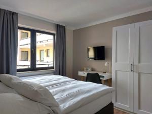 sypialnia z łóżkiem, oknem i biurkiem w obiekcie Landhuus Dieksee w mieście Malente