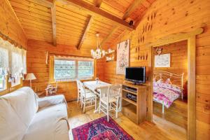 a living room with a table and a tv in a cabin at Orserose Chalet 5 I Fus in Forno di Zoldo