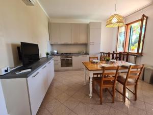 cocina y comedor con mesa y TV en Villaggio Mietta, en Castiglioncello