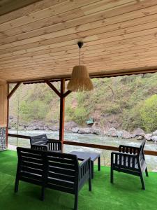 a porch with two benches and a table with a view at Karadeniz Suit in Rize
