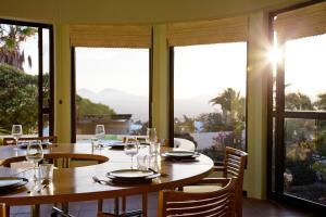 a dining room with tables and chairs and windows at Villa Dora Bella in Nazaret