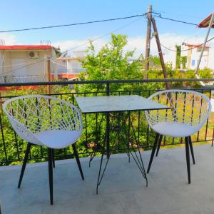 Duas cadeiras e uma mesa numa varanda em Κωνσταντίνος Έλενα Studios em Pefki